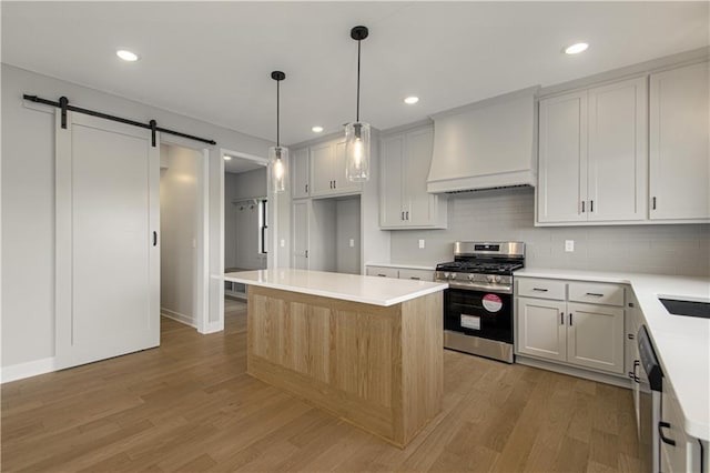 2327 Fishing Ln, Kearney, MO 64060 - kitchen featuring stainless steel appliances, custom range hood, light wood-style floors, a barn door, and recessed lighting