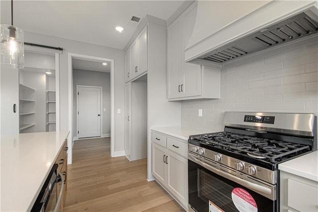 2327 Fishing Ln, Kearney, MO 64060 - kitchen with stainless steel gas range, custom exhaust hood, light countertops, white cabinets, and recessed lighting