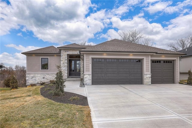 prairie-style home featuring a garage and a front lawn