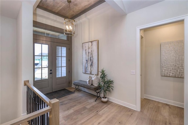 foyer entrance featuring an inviting chandelier, french doors, and light wood-type flooring