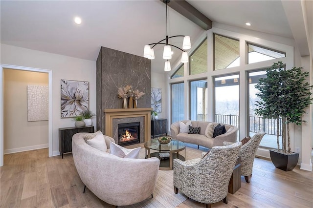 living room featuring high vaulted ceiling, beam ceiling, light hardwood / wood-style floors, and a chandelier