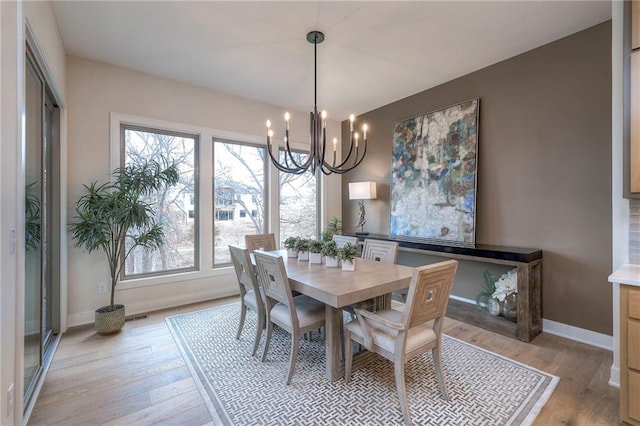 dining room featuring light hardwood / wood-style flooring and a notable chandelier