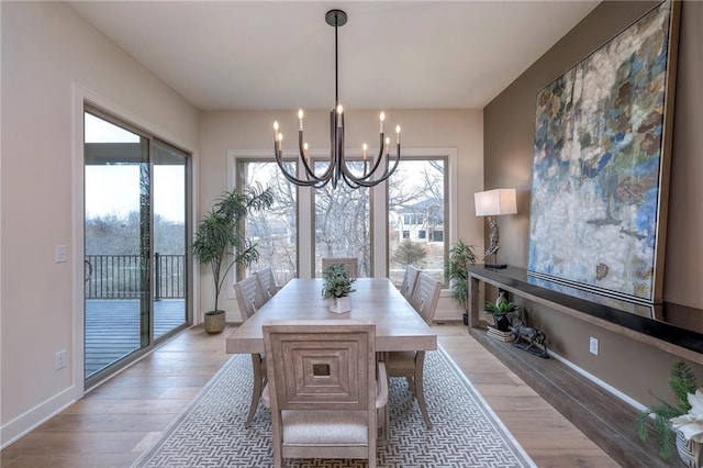 dining area with a chandelier and light hardwood / wood-style flooring