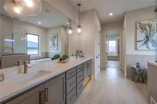 bathroom featuring plenty of natural light, tile patterned flooring, a shower with door, and vanity