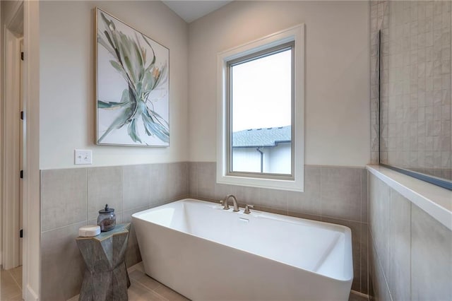 bathroom with a bathing tub and tile walls