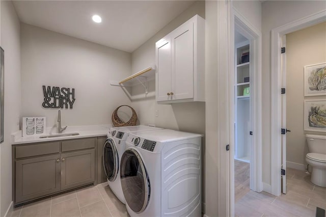 clothes washing area with cabinets, separate washer and dryer, and sink