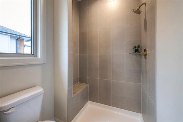 bathroom with toilet and tiled shower