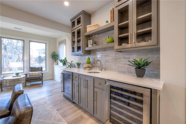 bar featuring tasteful backsplash, sink, gray cabinetry, and wine cooler