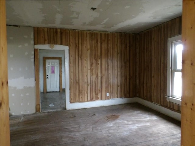 unfurnished room with wooden walls