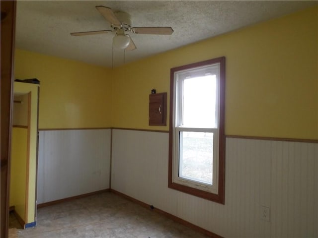 unfurnished room featuring electric panel and ceiling fan