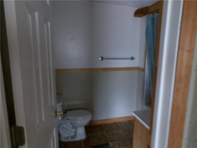 bathroom with parquet floors and toilet