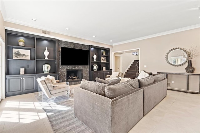 living room featuring stairs, ornamental molding, a high end fireplace, and visible vents