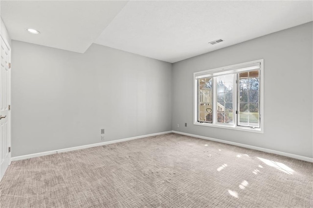 carpeted empty room with visible vents and baseboards