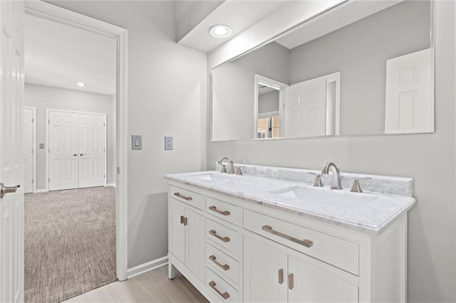 full bathroom with recessed lighting, a sink, baseboards, and double vanity