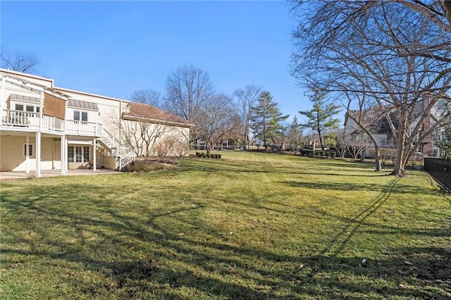 view of yard with fence, stairway, a wooden deck, and a patio