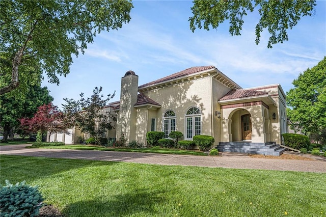 4101 W 123rd St, Leawood, KS 66209 - mediterranean / spanish house featuring a chimney, a front lawn, stucco siding, and a tile roof
