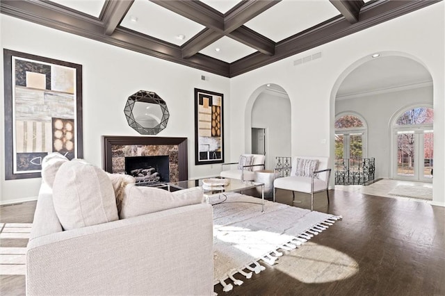 4101 W 123rd St, Leawood, KS 66209 - living area with arched walkways, ornamental molding, a fireplace, beamed ceiling, and wood finished floors