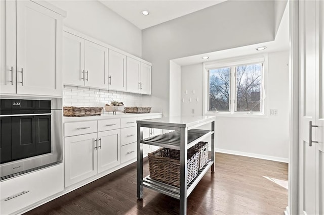 4101 W 123rd St, Leawood, KS 66209 - kitchen featuring stainless steel oven, backsplash, white cabinetry, dark wood-type flooring, and recessed lighting