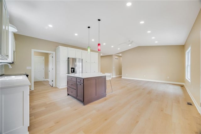 1013 S Main St, Holden, MO 64040 - kitchen with white cabinets, light wood-style floors, light countertops, and stainless steel fridge