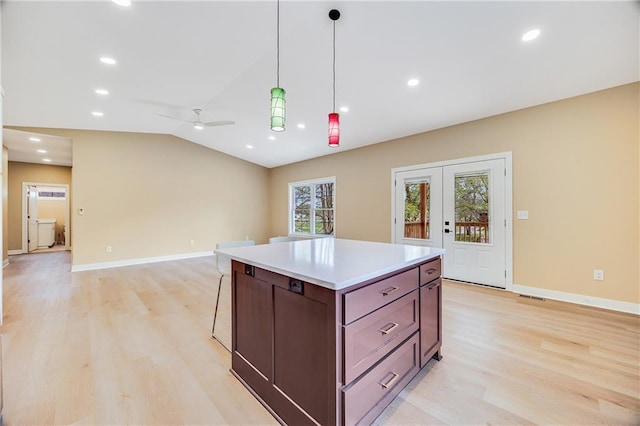 1013 S Main St, Holden, MO 64040 - kitchen featuring light wood-style flooring, ceiling fan, light countertops, decorative light fixtures, and a kitchen island