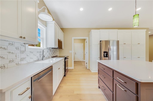 1013 S Main St, Holden, MO 64040 - kitchen with white cabinets, stainless steel appliances, a sink, light wood-style floors, and light countertops