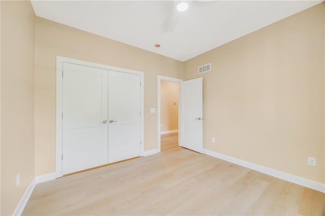 1013 S Main St, Holden, MO 64040 - unfurnished bedroom featuring baseboards, visible vents, light wood-style floors, and a closet