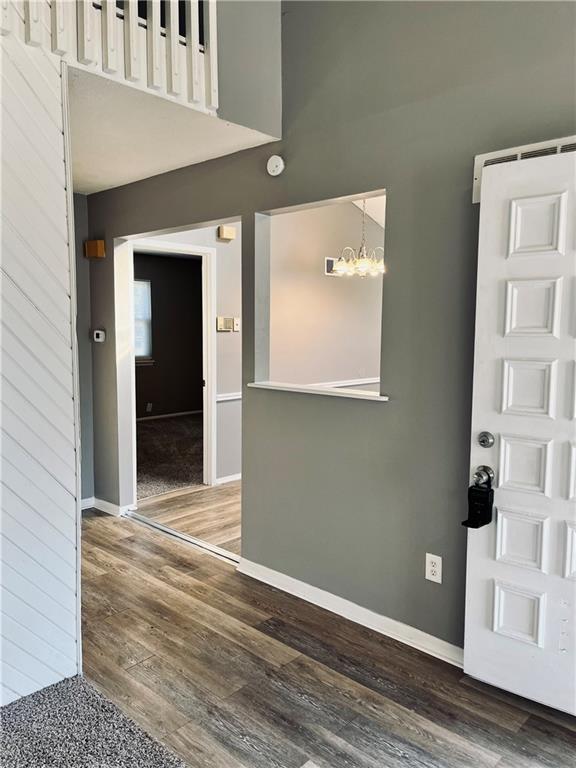 foyer entrance featuring an inviting chandelier and dark hardwood / wood-style flooring