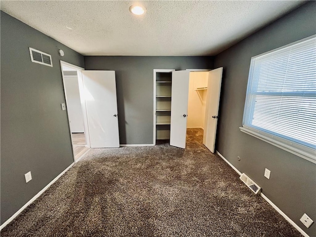 unfurnished bedroom with carpet flooring and a textured ceiling