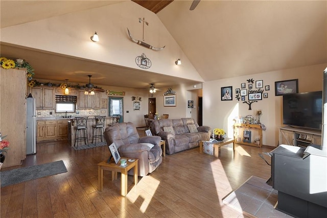 living room with ceiling fan, high vaulted ceiling, and dark wood finished floors