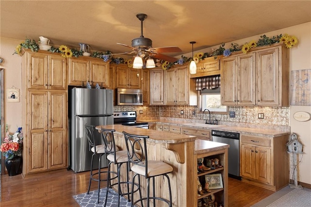 kitchen with appliances with stainless steel finishes, light countertops, a sink, and tasteful backsplash