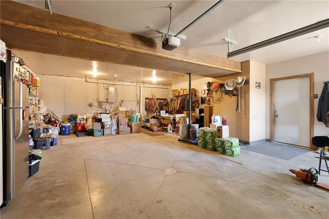 garage featuring freestanding refrigerator and a garage door opener