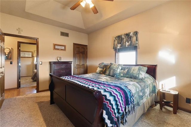 bedroom featuring a tray ceiling, visible vents, vaulted ceiling, ceiling fan, and baseboards