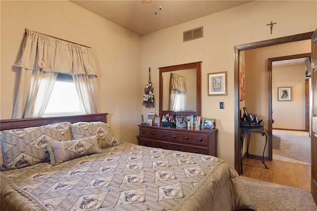 bedroom featuring baseboards, visible vents, and wood finished floors