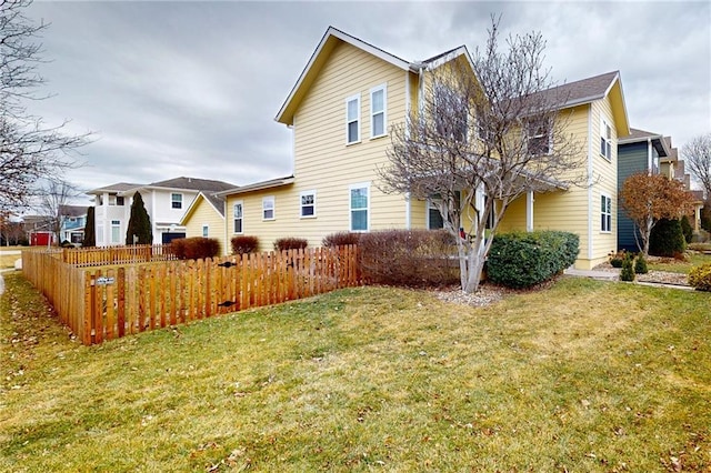 back of house featuring fence and a lawn