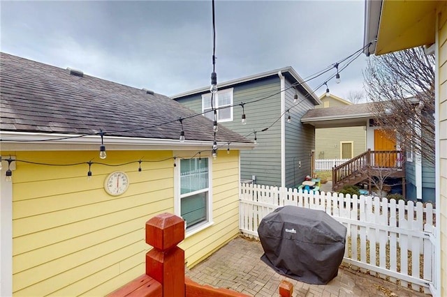 rear view of property with a patio area, fence, and roof with shingles