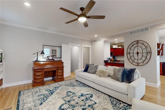 living area featuring light wood-style floors, baseboards, and visible vents