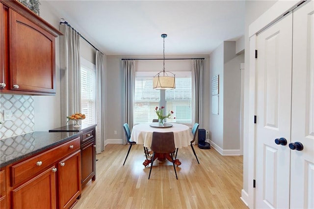 dining room featuring light wood-type flooring and baseboards