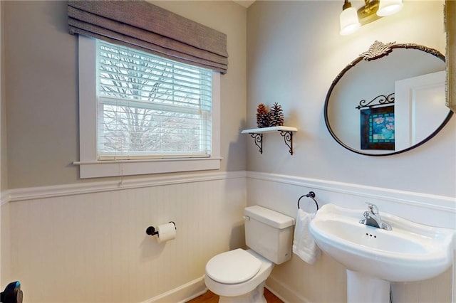 bathroom with wainscoting, a sink, and toilet