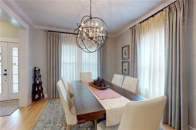 dining room with a healthy amount of sunlight, light wood-style floors, and ornamental molding