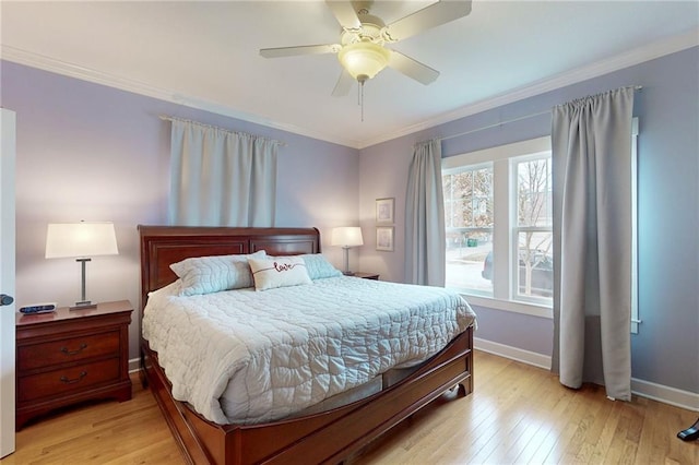 bedroom with light wood-type flooring, ceiling fan, baseboards, and crown molding