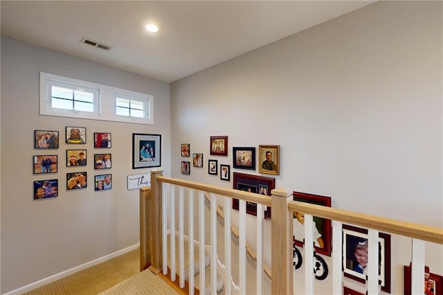 hall featuring baseboards, visible vents, carpet flooring, an upstairs landing, and recessed lighting