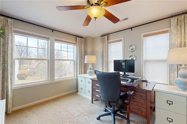 office area with a ceiling fan, light colored carpet, visible vents, and baseboards