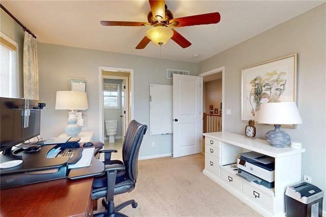 home office with baseboards, ceiling fan, visible vents, and light colored carpet