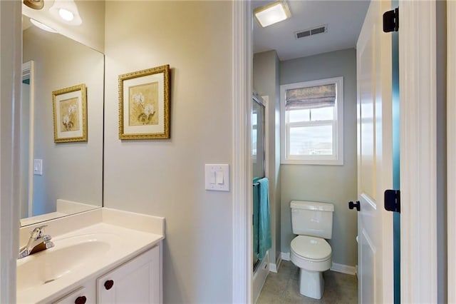 bathroom with visible vents, toilet, a stall shower, vanity, and baseboards