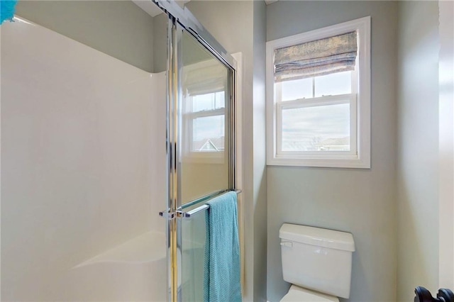 bathroom featuring a stall shower and toilet