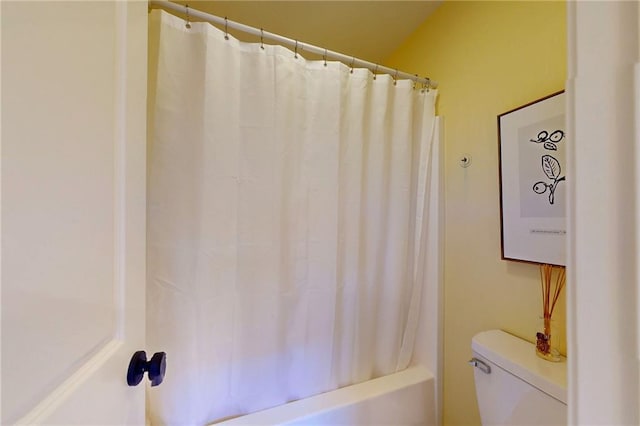 bathroom with toilet and shower / bath combo with shower curtain