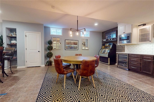 dining space featuring wine cooler, light tile patterned flooring, and baseboards