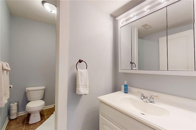 bathroom featuring visible vents, toilet, vanity, baseboards, and tile patterned floors