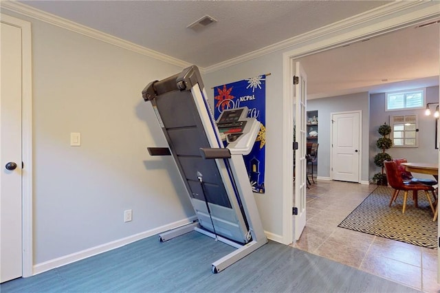 workout area with visible vents, crown molding, baseboards, and wood finished floors