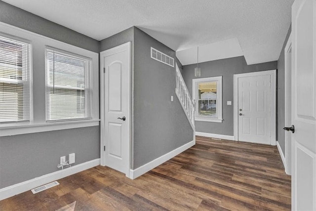 foyer entrance featuring dark hardwood / wood-style flooring and a textured ceiling